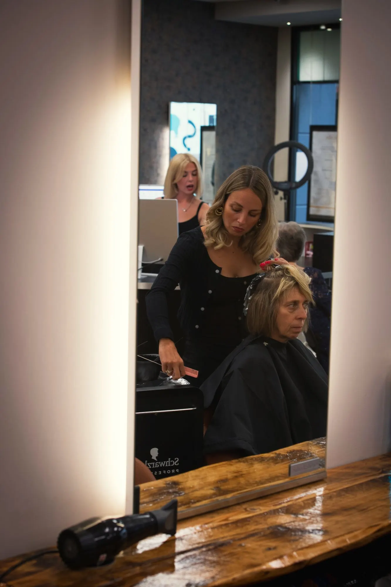 A stylist working at the mirror at Deesigner Hair Studio, Ipswich