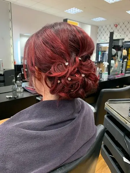 Rouge profond, coiffé en chignon, réalisé chez Deesigner Hair Studio, Ipswich, par Emma
